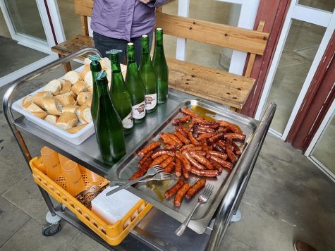 Sausages, drinks and slices of baguette on a tray, to be served to students learning Basque