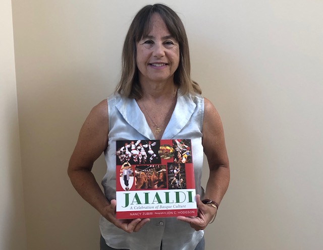 Author Nancy Zubiri holding the book Jaialdi: A Celebration of Basque Culture