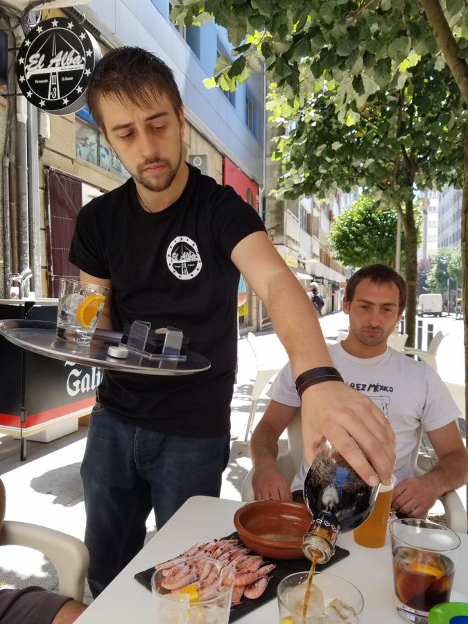 Waiter serving a drink at an outdoor table in Spain