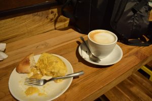 A piece of potato omelet next to a cup of coffee.